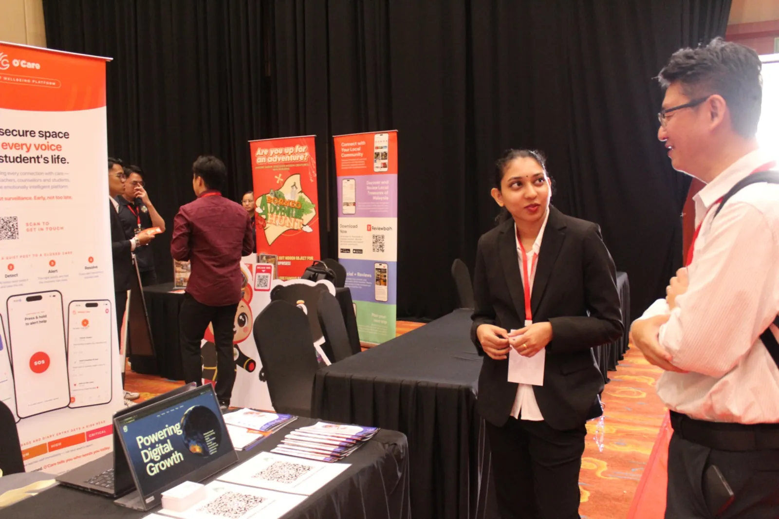Conversation with a visitor at the OC Global Technology booth