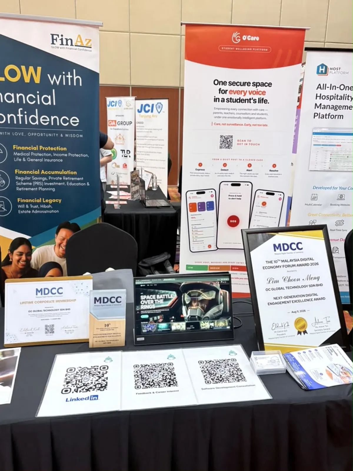 The OC Global Technology booth display with both MDCC recognitions on the table