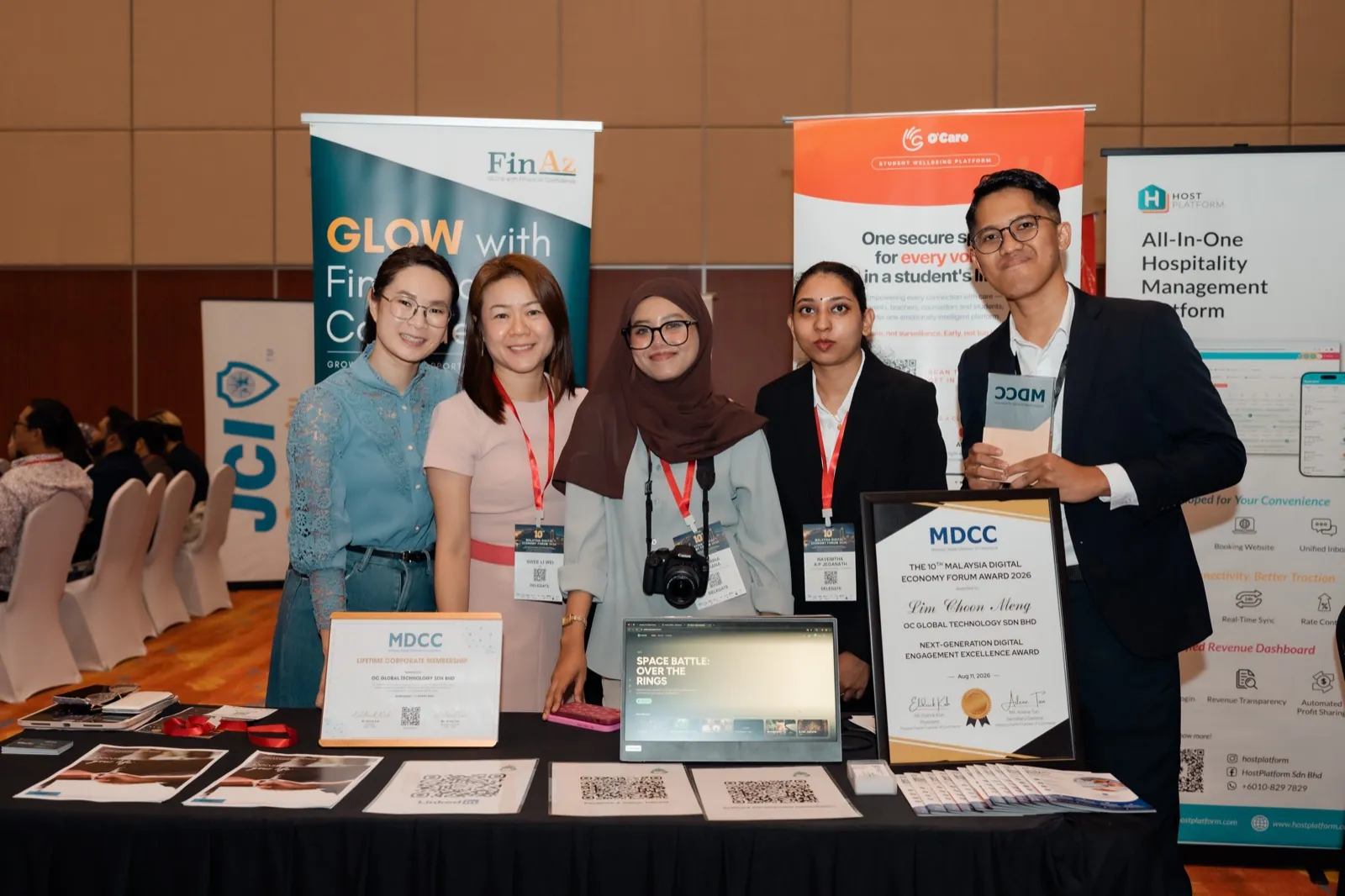 OC Global Technology team at the exhibition booth with both MDCC recognitions, MDEF2026